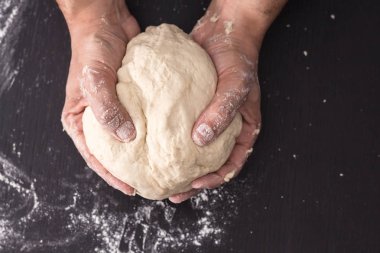 Erkek hazırlık closeup pişirme yoğurma hamur, eller.