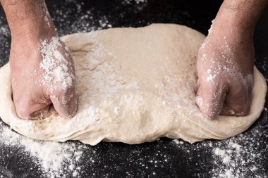 Erkek hazırlık closeup pişirme yoğurma hamur, eller.