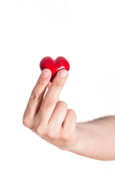 Mano masculina sosteniendo el corazón rojo, primer plano sobre fondo blanco . — Foto de Stock