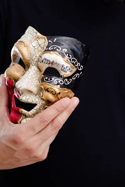 Mão masculina segurando máscara de carnaval de rosto cheio, fundo close-up . — Fotografia de Stock