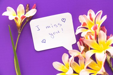 Çiçekler mor yüzeyi ile Not kelimelerle kalp şeklinde 