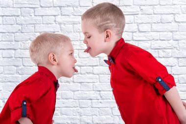 İki kardeş oynamak ve eğlenmek, birlikte vakit geçirmek. Aynı moda giysiler içinde gömlek giymiş çocuk