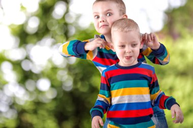 İki kardeş oynamak, eğlenmek, arkadaş. Aynı kıyafetleri giymiş çocuk.
