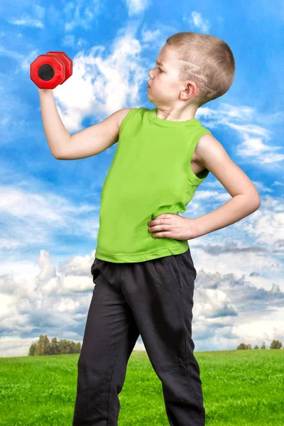 Jongen oefent met halters, in de frisse lucht. Sport, een gezonde levensstijl. — Stockfoto