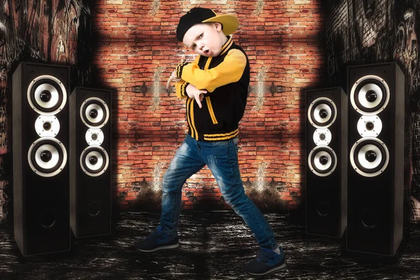 Den lilla pojken i stil med Hip-Hop. Barnmode. Mössa och jacka. Den unga Rapper.Graffiti på väggarna. Cool HipHop dj. — Stockfoto