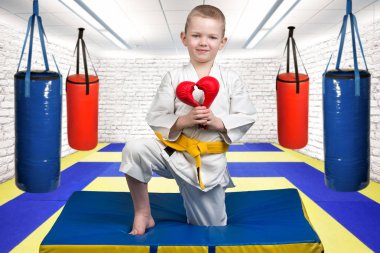 Karate çocuk atlet eldiven, yapılan bir kalp aşk, taziye ilanı verir. Karate salonunda mindere.