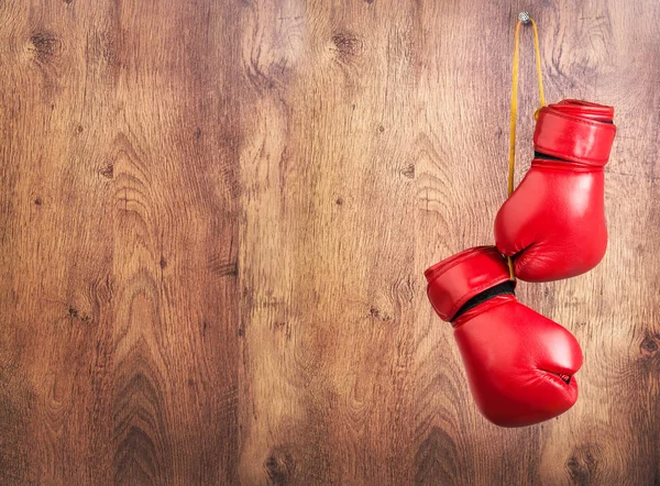 Paar rode lederen bokshandschoenen opknoping op een spijker op een houten muur. — Stockfoto