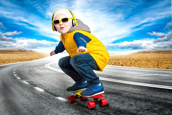 Menino fazendo truques em um skate, patinar na estrada.O menino no estilo de Hip-Hop  . — Fotografia de Stock