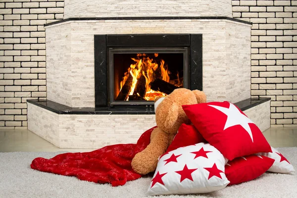 Teddy bear feküdt a párnán, borított egy takarót, és nézni a lángokat, a tűz a kandallóban. — Stock Fotó