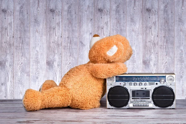 Big Teddy bear listening Retro radio-cassette player.Vintage style . — Stock Photo, Image