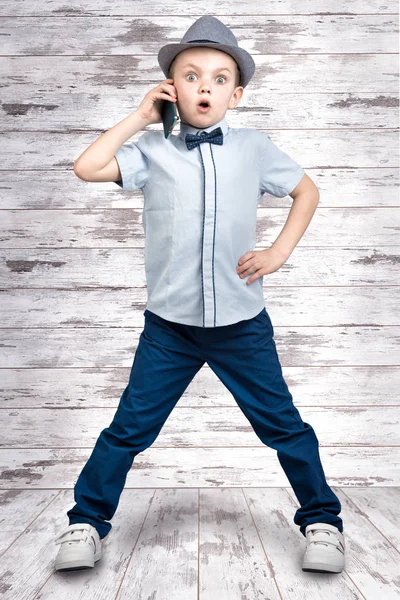 Kleine baas gesprekken op zijn mobiele telefoon. Emotioneel gesprek. Kid's fashion. — Stockfoto