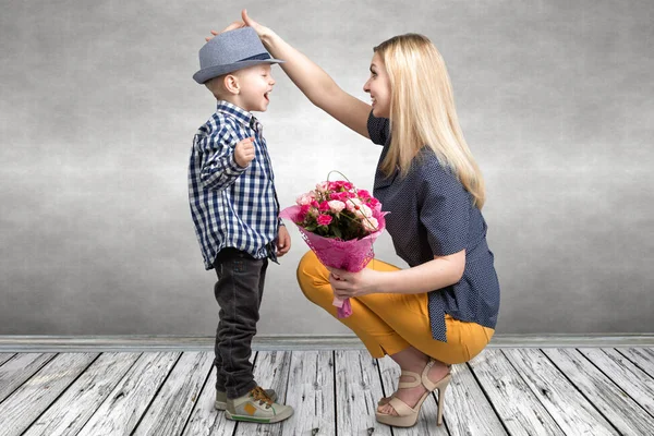 Liten son ger sin älskade mor en vacker bukett av rosa rosor. Våren, begreppet familjesemester. Kvinnodagen, mors dag. — Stockfoto