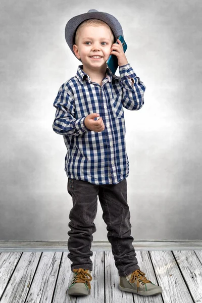 Mały chłopiec w rozmowach kapelusz na jego telefon komórkowy. Trochę boss . — Zdjęcie stockowe