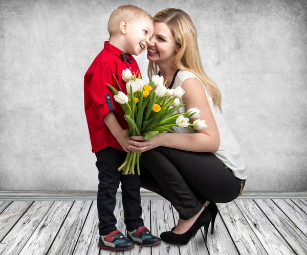 小儿子给他心爱的母亲一束美丽的郁金香。春天，概念的家庭度假。妇女节. — 图库照片