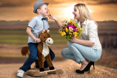 Oğlu ata, bir sepet çiçek sevgili anne verir. Küçük Prens sırtında. Bahar, kadınlar günü