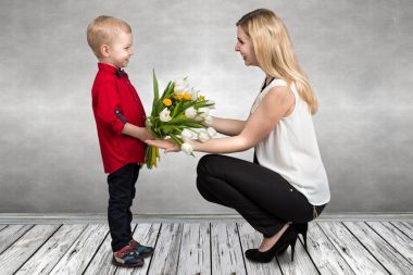 Küçük oğlu sevgili annesi güzel Lale buketi verir. Bahar, kavram aile tatili. Kadınlar Günü.