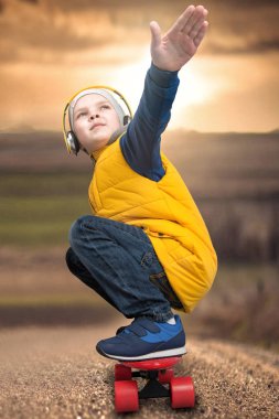 Bir kaykay, paten yol üzerinde yapan çocuk. Doğa sporları, moda çocuk.