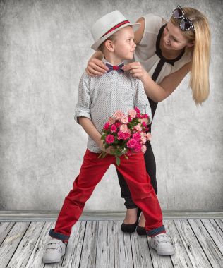 Küçük oğlu sevgili annesi pembe güller güzel bir buket verir. Bahar, kavram aile tatili. Kadınlar Günü, anneler günü.