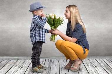 Küçük oğlu sevgili annesi güzel Lale buketi verir. Bahar, kavram aile tatili. Kadınlar Günü.