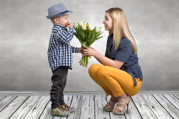 Küçük oğlu sevgili annesi güzel Lale buketi verir. Bahar, kavram aile tatili. Kadınlar Günü.