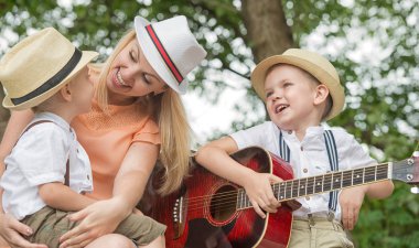 Genç anne ve iki oğlu ormanda, Zihnimin içinde şarkılar bir gitar ile dinlenme.