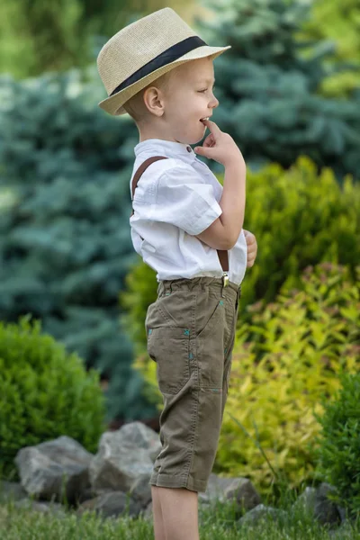 Un niño pequeño con sombrero de paja camina por el Parque.Niño pequeño y tímido — Foto de Stock