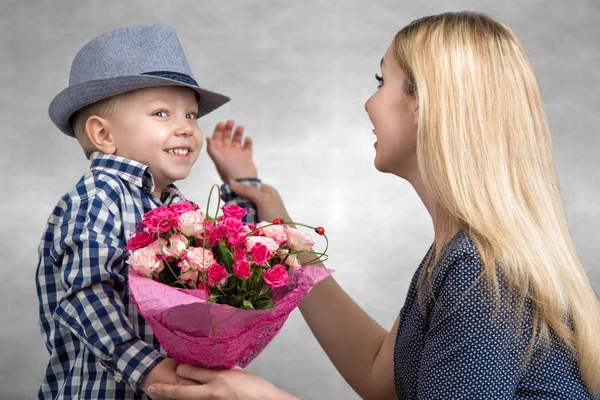 小儿子给他心爱的母亲一束美丽的粉红玫瑰。春天，概念的家庭度假。妇女的一天，母亲的一天. — 图库照片