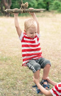  Küçük çocuk ormanda derme çatma bir salıncak üzerinde sürme.