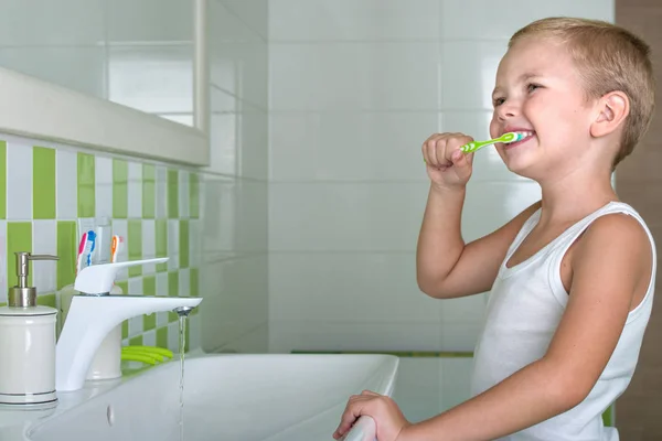Мальчик чистит зубы в ванной комнате. Начало нового дня — стоковое фото