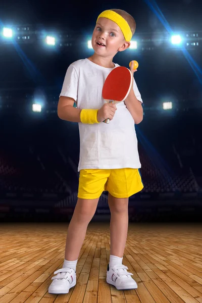 Boy plays table tennis in the sports hall.
