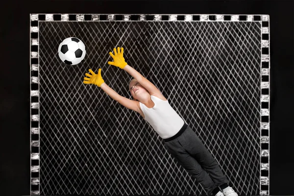 Jongen keeper vangt een voetbal. Tekeningen met krijt op de muur. — Stockfoto