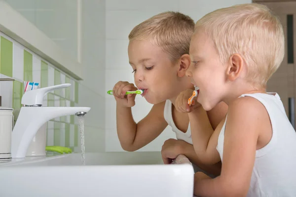 Dois irmãos escovam meus dentes no banheiro.O início de um novo dia — Fotografia de Stock