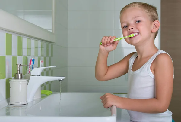 Мальчик чистит зубы в ванной комнате. Начало нового дня — стоковое фото