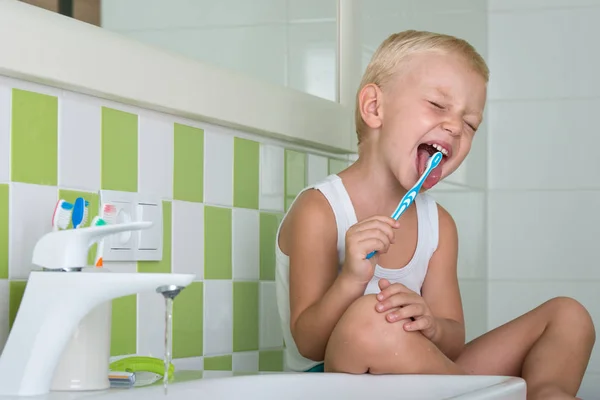 Маленький мальчик чистит зубы в ванной комнате. Начало нового дня — стоковое фото