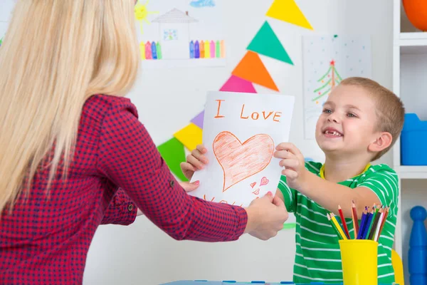 Çocuk annesi boyalı bir kartpostal verir..