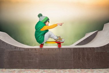 Küçük çocuk kaykay üzerinde dik atlar. Doğa sporları.