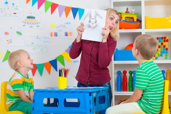 Kinderen met mam en draw foto's in de kinderkamer. — Stockfoto