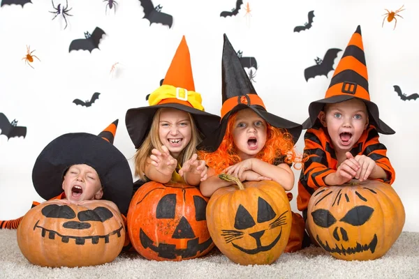 Niños alegres en trajes de halloween celebrando halloween —  Fotos de Stock