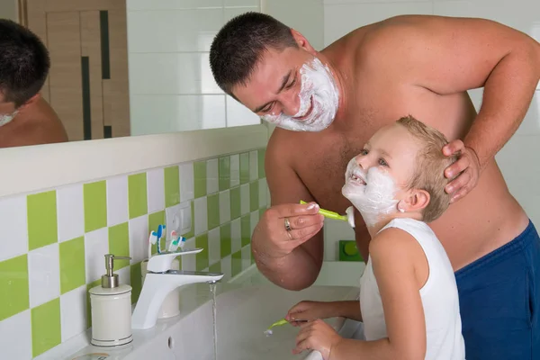 Dad teaches to shave her little son.Child wants to be like dad. — Stock Photo, Image