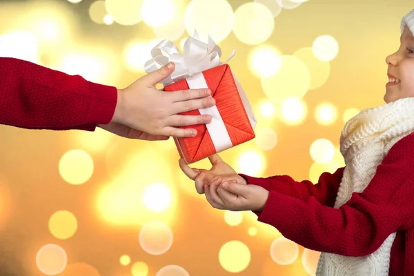 A testvérek a karácsonyi ajándékok cseréje. A kezek, a gyermek egy ajándék. Kellemes karácsonyi ünnepeket és boldog ünnepek! — Stock Fotó