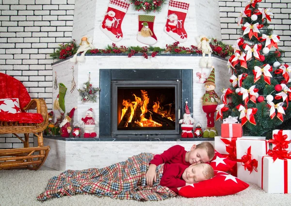 Kellemes karácsonyi ünnepeket és boldog ünnepek! Két testvér aludni a nappaliban, az emeleten a fa alatt. Előre az ajándékokat a Mikulás. — Stock Fotó