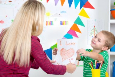 Çocuk annesi boyalı bir kartpostal verir..