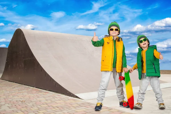 Dos hermanos montando en colinas empinadas para patinar en el skate Park.Deportes extremos . — Foto de Stock