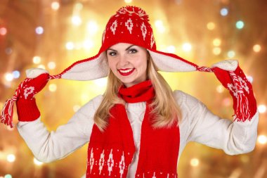 Örme kırmızı şapka, eşarp ve eldiven bir Noel süsleme ile güzel bir genç kadın portresi.