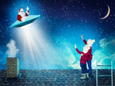 Noel gecesi iki kardeş evin çatısında stand ve Noel Baba'nın uçuş Ufo için bakmak.