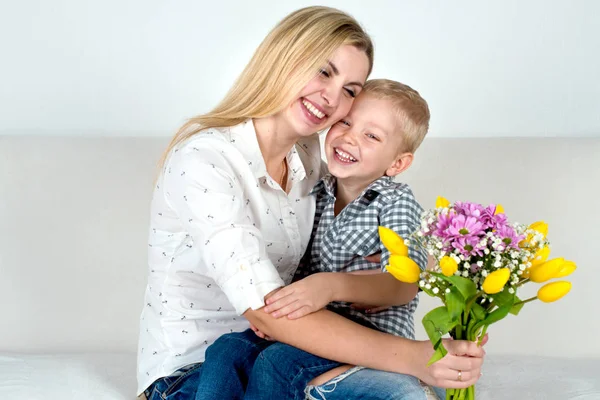Son gives his beloved mother a beautiful bouquet of tulips.The concept of the celebration,women\'s day.