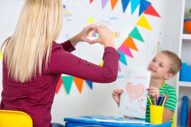 Çocuk annesi boyalı bir kartpostal verir..