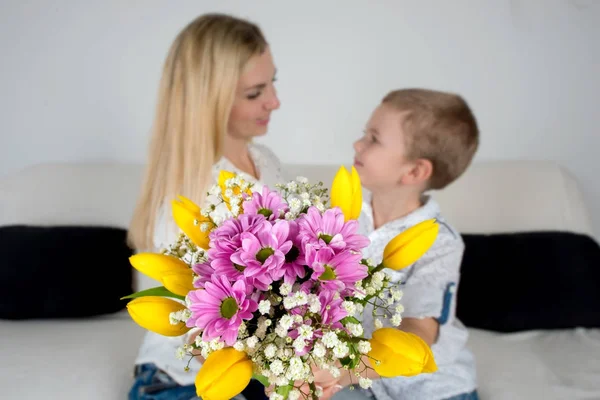 Son gives his beloved mother a beautiful bouquet of tulips.The concept of the celebration,women\'s day.