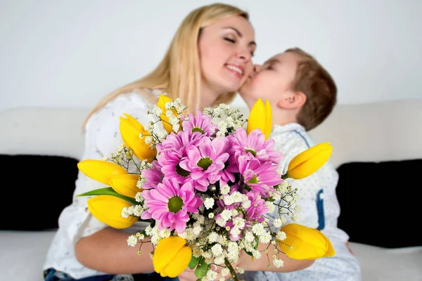 Son gives his beloved mother a beautiful bouquet of tulips.The concept of the celebration,women\'s day.