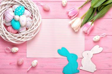 Paskalya yumurtaları bir hasır sepet ve Lale pembe bir arka plan üzerinde bir buket. Paskalya için tatil tebrik kartı!